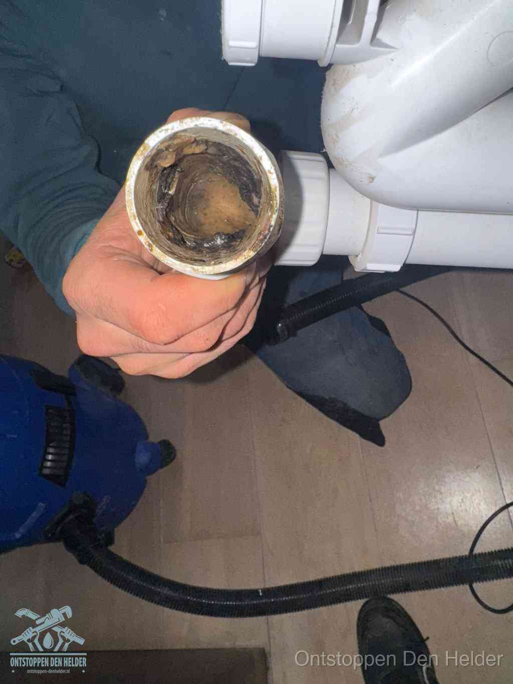 Een losgekoppeld afvoerbuisstuk dat van binnen volledig is dichtgeslibd, het gevolg van een verstopping te lang laten zitten in Den Helder