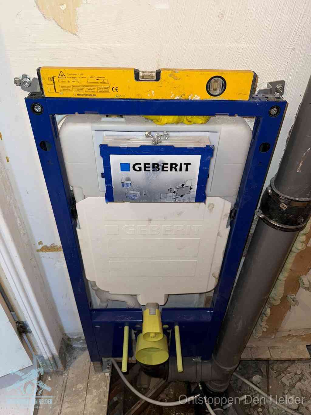 Een Geberit inbouwreservoir met frame voor een hangtoilet tegen de wand, met de afvoerbocht naar de vloer, kenmerkend voor een verstopt hangtoilet in Den Helder