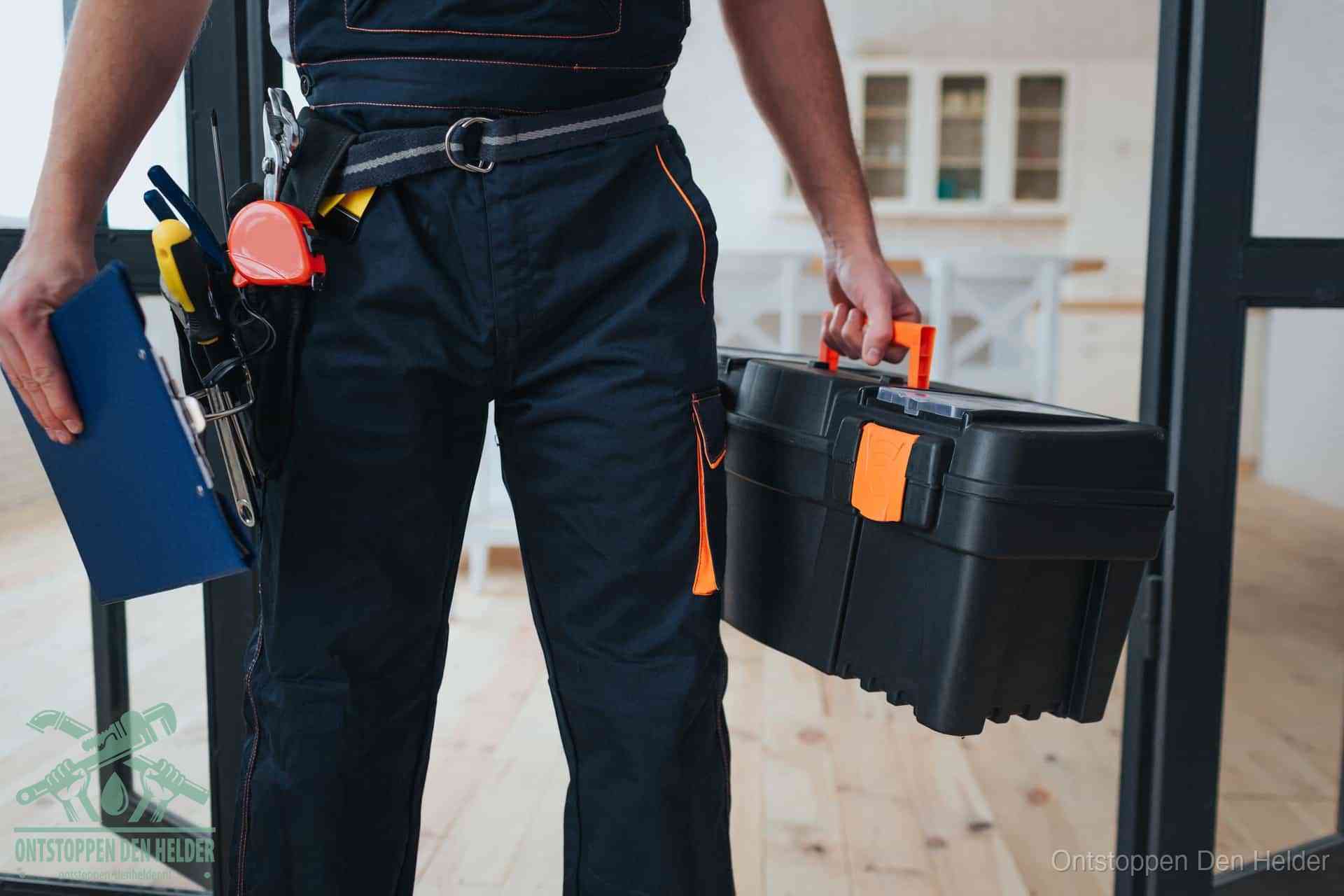 Een monteur met gereedschapsriem en klembord, klaar om een transparante prijs voor het afvoer ontstoppen in Den Helder te geven