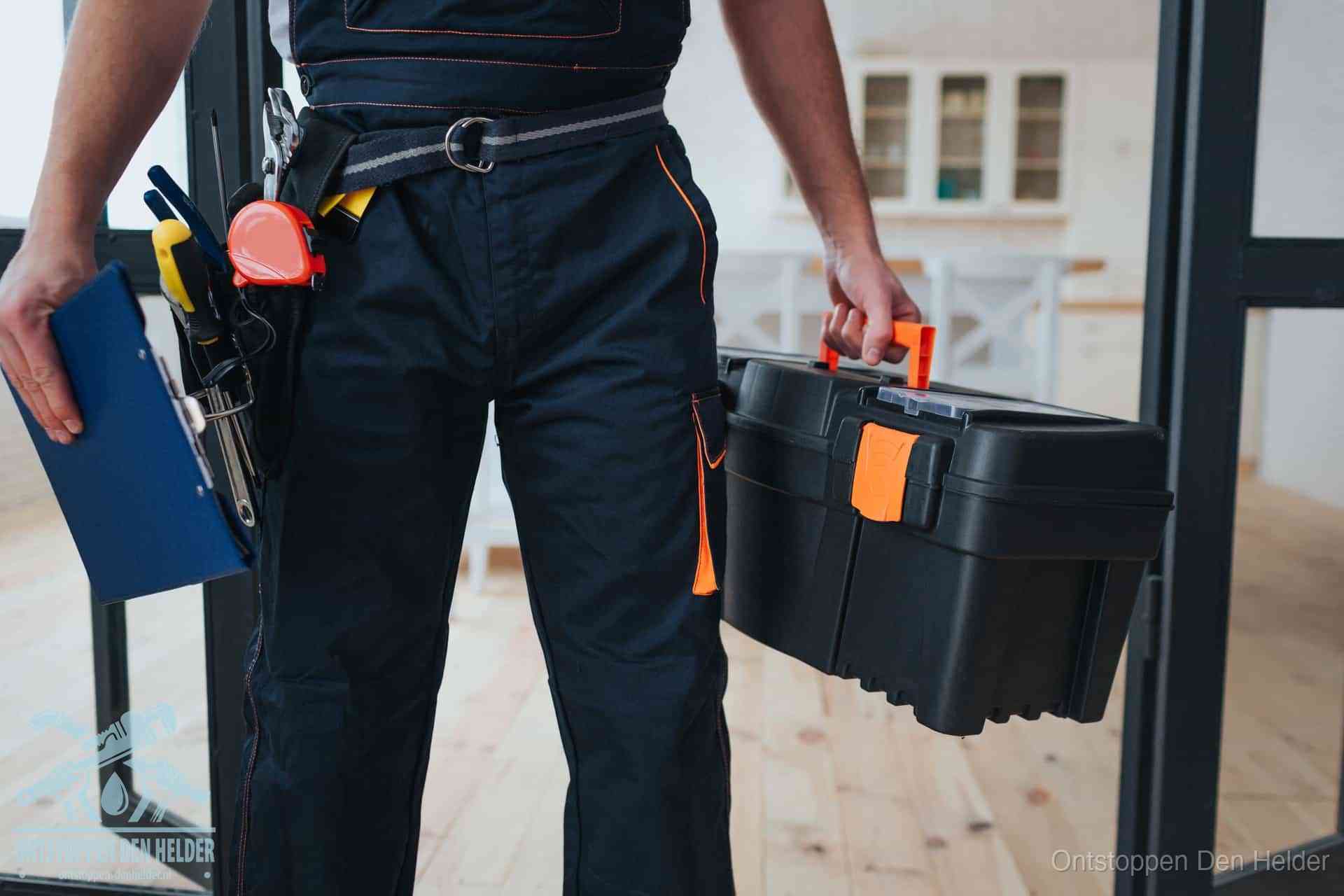 Een monteur met gereedschapsriem en klembord, klaar om een transparante prijs voor het wc ontstoppen in Den Helder te geven