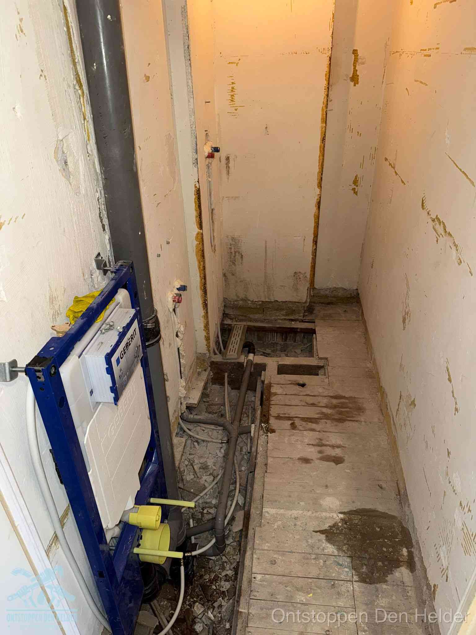 Een opgebroken toiletruimte tijdens renovatie met een Geberit inbouwreservoir en blootliggende oude afvoerleidingen, typisch voor oudere woningen in Den Helder